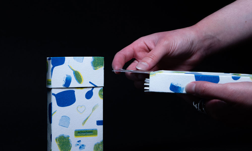 Voici une photographie de l'édition César Salade qui se compose d'une boîte au format d'un téléphone, contenant des cartes. 